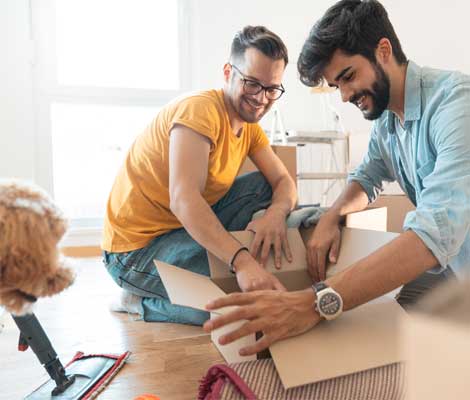 couple unpacks in new home while their dog watches